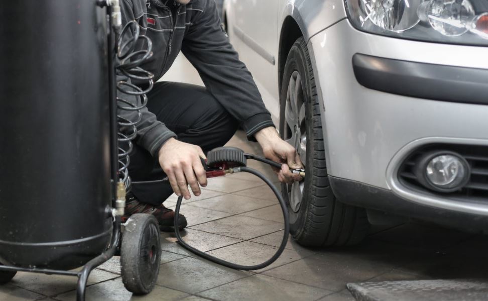 Auto tech checking tire pressure