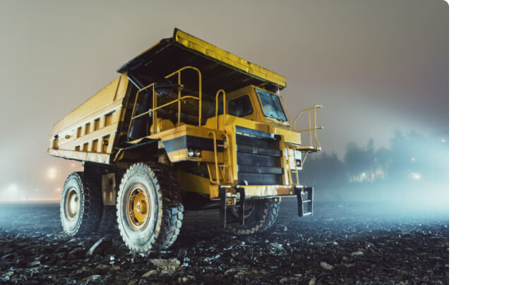 Yellow rigid haul truck working a jobsite at night