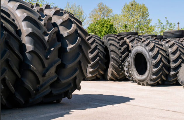 Stacked OTR tires of varying sizes in a commercial tire yard